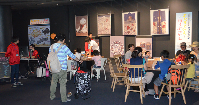大勢の親子連れでにぎわうKCG協力の「描いて撮って！ お絵描きワークショップ」。京都国立博物館に展示している文化財を表現した大型モザイクアート作品も展示されています＝7月8日，京都水族館「交流プラザ」